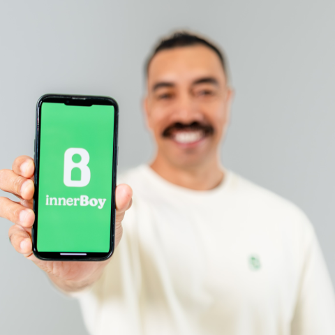 Matt holding a phone showing the innerBoy app