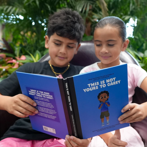 Two children reading This Is Not Yours to Carry